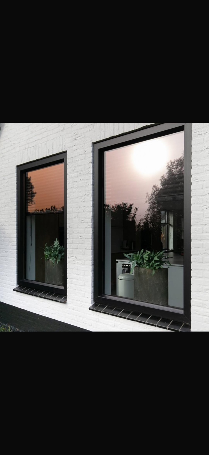 Twee antraciet kozijnen in een verzorgde witte gevel